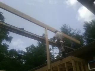 Carpenter setting a ridge beam over a new addition frame — Ice Dam Removal by Roofing Brothers in Cedar Crest