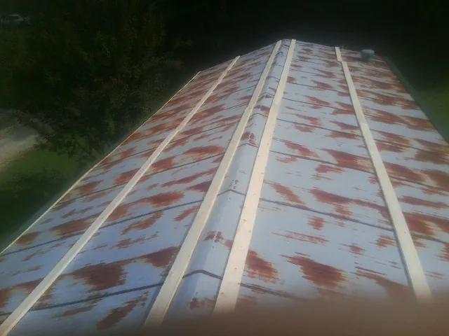 Rusted metal roof panels with new wood purlins before replacement — Storm Damage Roof Repair in Cedar Crest by Roofing Brothers