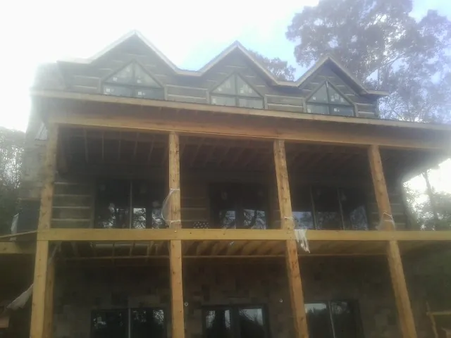 Dormers and porch framing on a large log home under construction — Roof Coating work by our crew in Cedar Crest