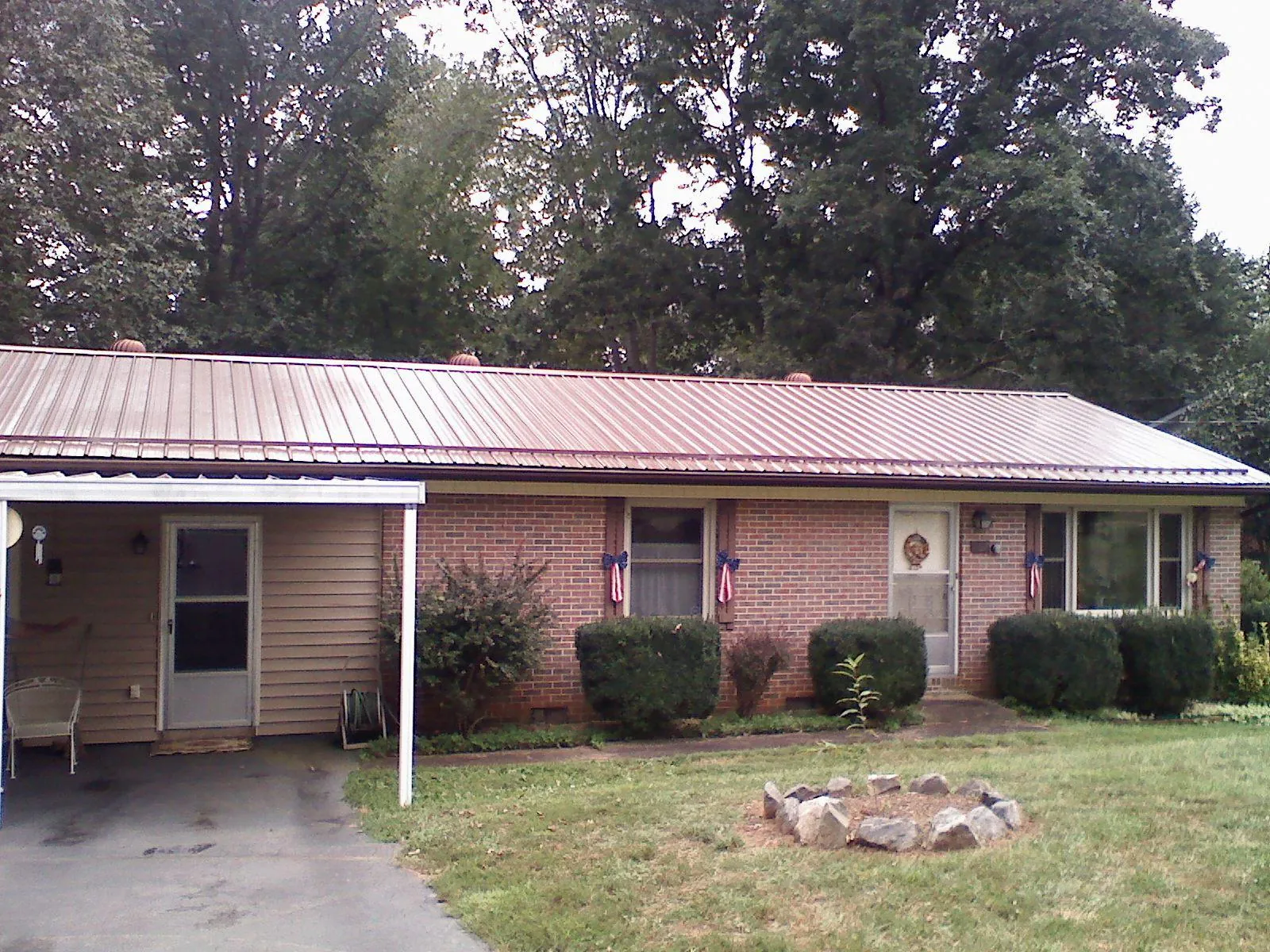 Bronze metal roof and carport on a brick ranch home — Roof Repair work by our crew in Cedar Crest
